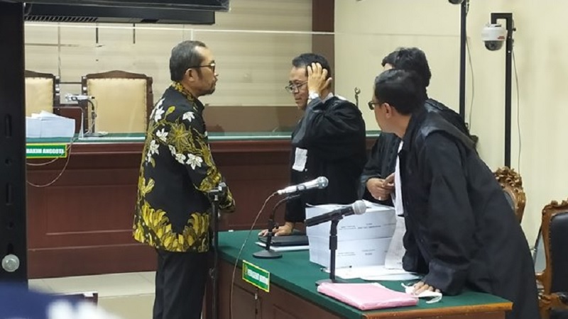 Mantan Wakil Ketua DPRD Jawa Timur Sahat Tua Simandjuntak berdialog dengan tim penasehat hukum usai pembacaan tuntutan di Pengadilan Tindak Pidana Korupsi.-Pace Morris-