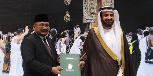 Menag Yaqut Cholil Qoumas menerima dokumen MoU kuota haji dari Menteri Haji Saudi Tawfiq, dengan latar belakang foto Kabah di sela Pameran Haji di Super Dome, Jeddah, Minggu (9/1)/Repro