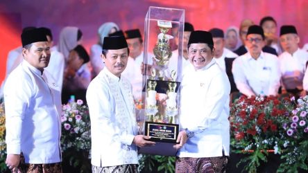 Kepala Kanwil Jateng Mustain Ahmad menerima piala juara umum MQKN 2023 dari Dirjen Pendis Ali Rhamdani. (Foto: Dok Kemenag)